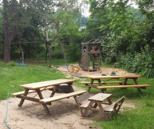 Garten der Kindergruppe Wonneproppen mit Spielgeräten und Picknick Tischen