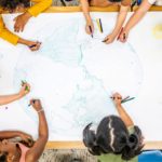 Kinder der Kindergruppe, die gemeinsam eine Weltkugel malen