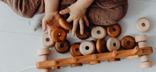 Kind der Kindergruppe Flow spielt mit Holz-Spielzeug